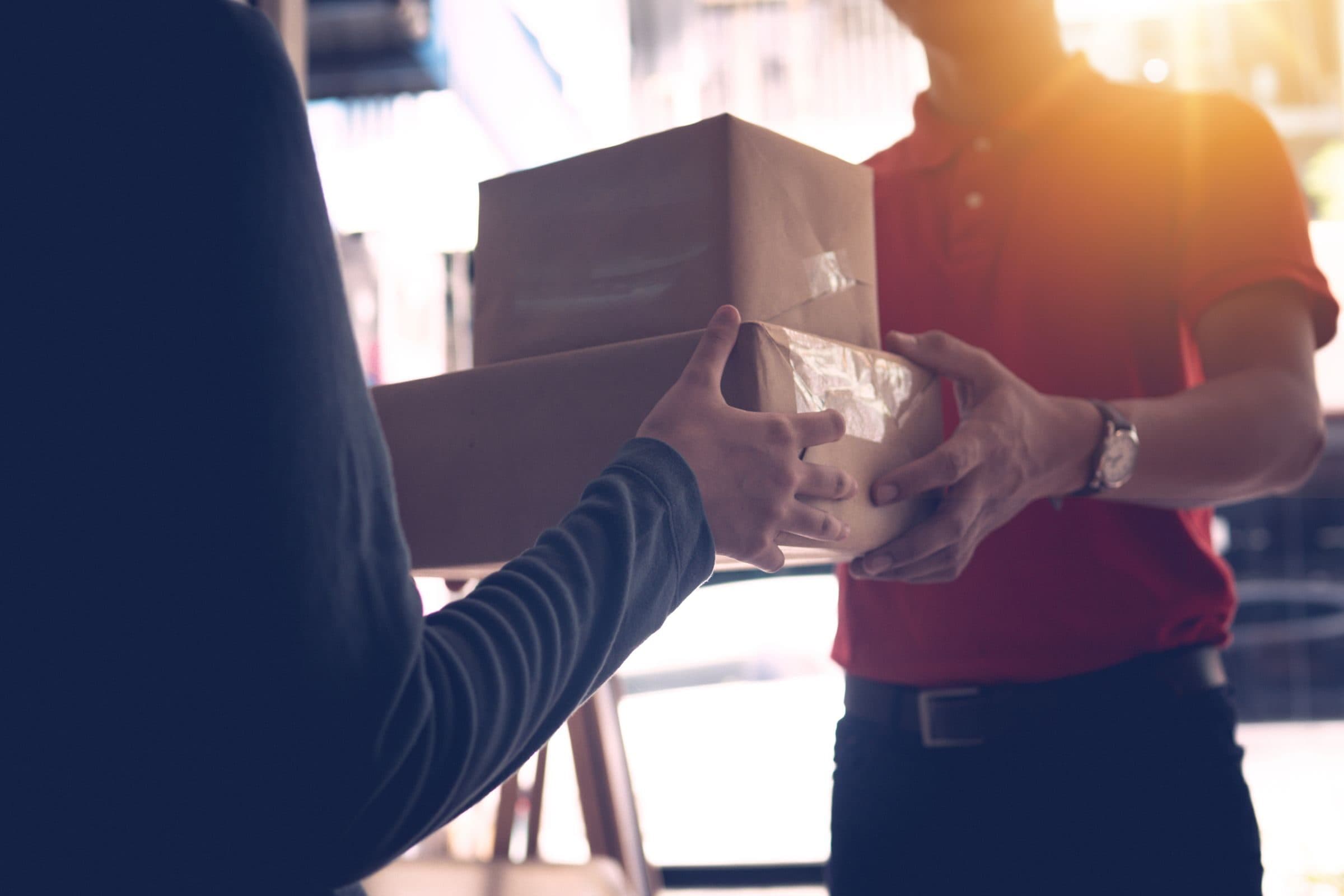 A courier handing printed documents to someone at their door